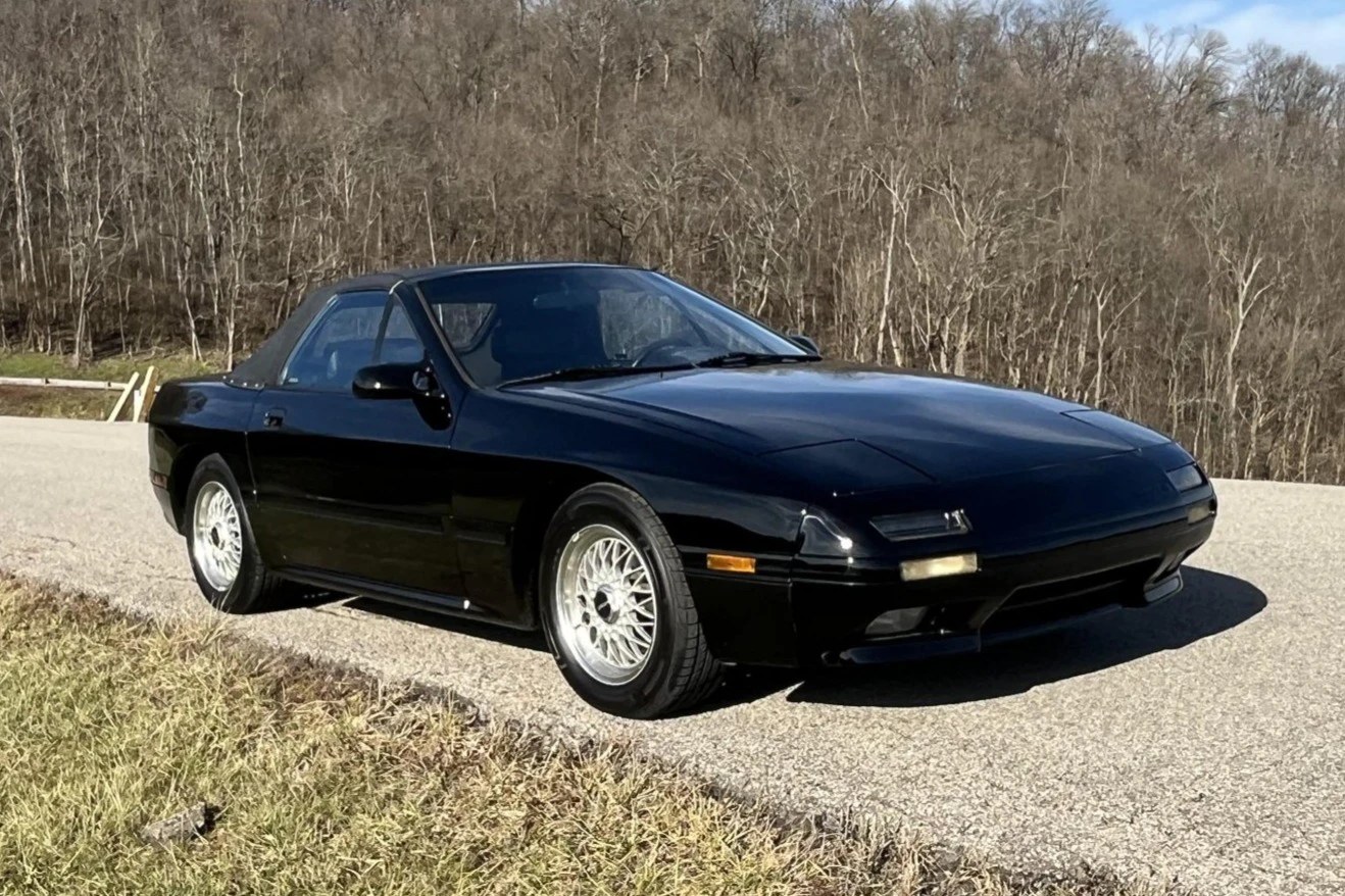 Black 1990 Mazda RX-7 Turbo convertible with its top up, photographed outdoors — same model shown for reference